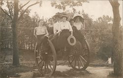 Women and gentleman sitting on a military cannon Postcard