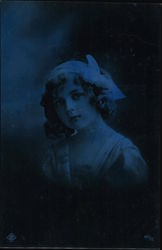A young girl win a small hat with a bow looks into the distance Postcard