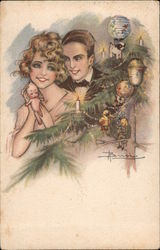 Man and Woman admire a Christmas tree with ornaments, candles, and toys Postcard
