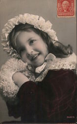 Girl with a burgundy coat and white hat, collar, and muff - Stamp on front of real-photo postcard Postcard