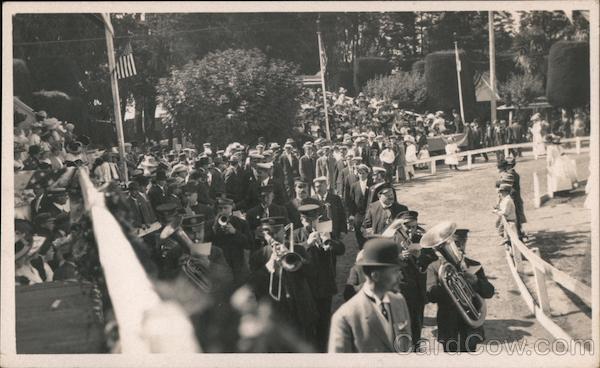 A marching band plays, while a big crowd is gathered for an event.