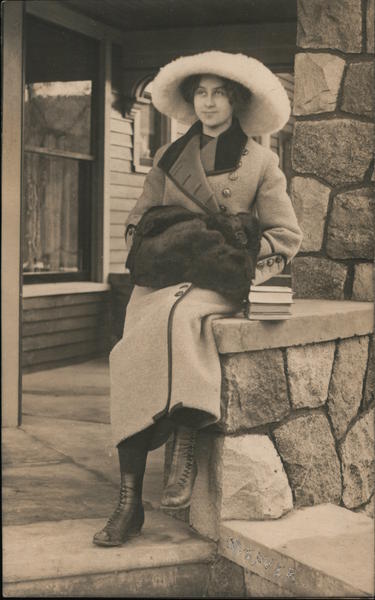 Woman posing on a stone porch rail. Women