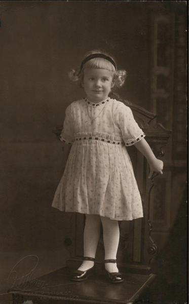 Little girl poses, standing on a chair Girls
