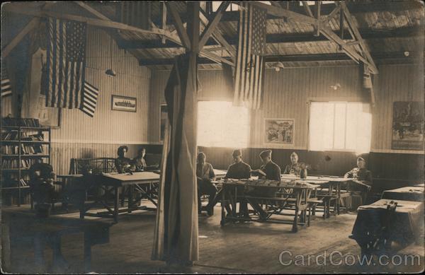 People in uniform sitting at tables inside a building