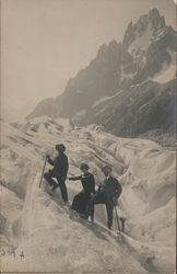 Three people posing while mountain climbing Postcard