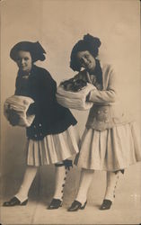 Two girls with fancy hats, coats, and muffs Postcard