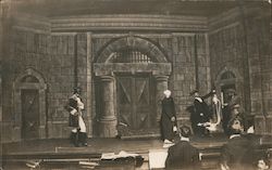 Theater scene by a large stone building - men in uniform and civilians Postcard