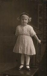 Little girl poses, standing on a chair Postcard