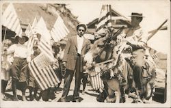 Man Riding Donkey with Flags in Background Postcard