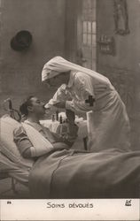 Red Cross Nurse feeding injured man Postcard