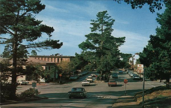 Ocean Avenue leading from shops and business area to the sand and cypress of scenic Carmel Beach and Bay