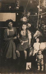 A Little Girl and Woman Next to Dolls Under a Christmas Tree Postcard