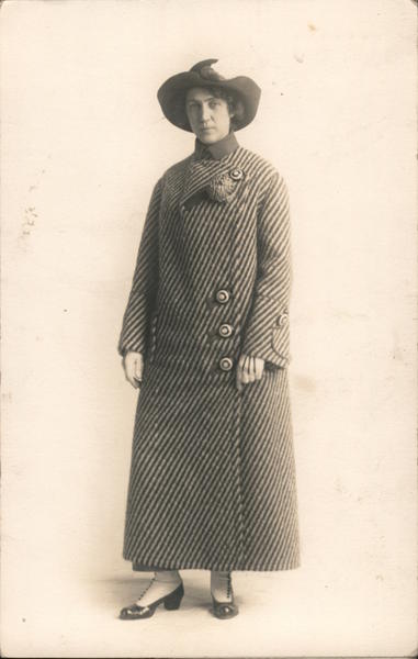 Woman wearing striped full length coat, hat Women