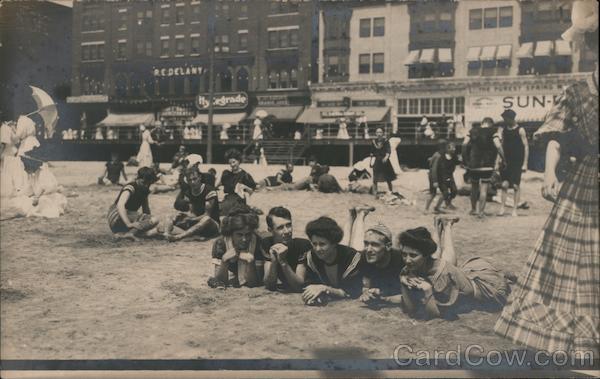 Beach near boardwalk. Beach goers in swimsuits, parasols Laquin Pennsylvania