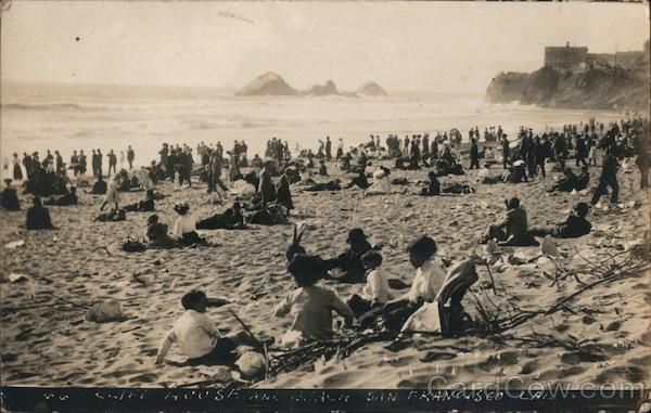 People on the beach in San Francisco with view of Cliff House and Seal Rock California
