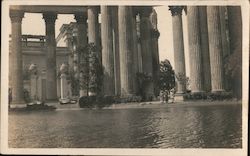 Three people standing by pond under huge coliseum columns Postcard