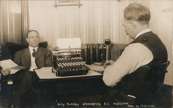 Billy Sunday answering his mail, typewriter on desk