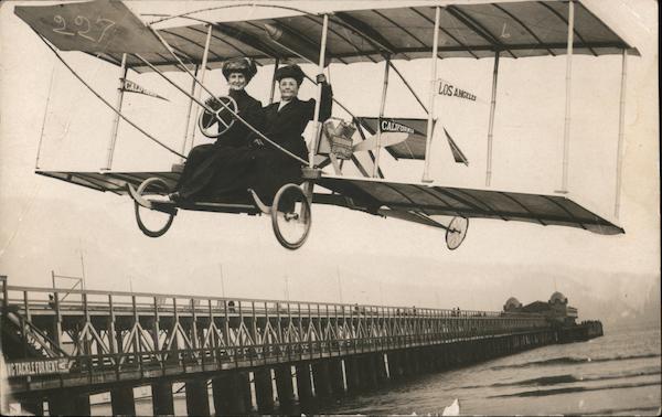 Two women flying in a biplane next to a pier (Studio Photo) Los Angeles California