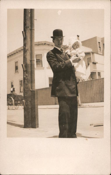 Man in bowler hat holding a baby Babies