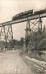 Railroad bridge with a steam locomotive crossing it Postcard