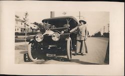 Woman standing next to convertible Car, large headlights, license 80374 Postcard