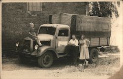 Little girl on hood of truck as man and women pose by truck with Pirmasens sign Postcard