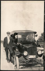 Man standing next to car on bridge Postcard