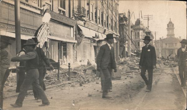 Ruins of street, Colins Bros. Druggist, men in streets, constable with badge, streetcar tracks San Francisco