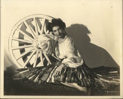 Woman in peasant blouse, ruffled skirt reclines against wagon wheel 1947 Original Photograph