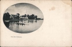 A Green Hurst lake view with a crew team on their boat rowing on the lake and homes along the shoreline. Postcard