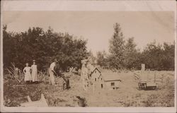 Miniature houses shown with man, girls and dog Postcard
