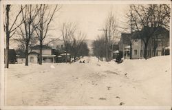 Photo of a town in winter, featuring children sledding in front of homes Postcard