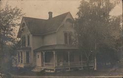 Wooden two-story house with ornamental woodwork and chimney Postcard