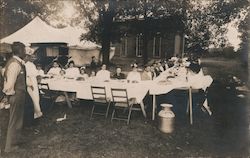 Sepia Photograph of People Seated for a Meal Outdoors at Long Tables Postcard