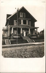 Man and Woman in Wedding Attire on Porch in Front of Two-Story Wooden House Postcard