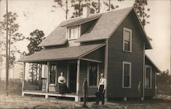 Man and Woman in front of newly built home Postcard