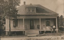 Family on Porch of House Postcard