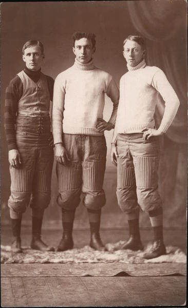 Three Football Players in Sweaters and Knee Pads