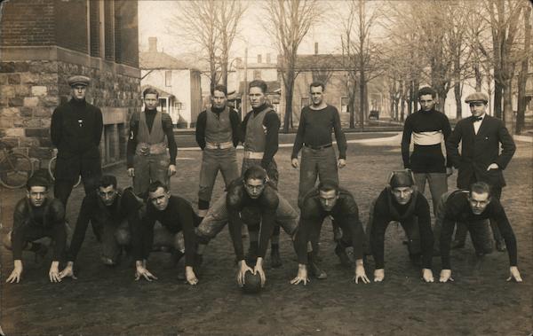 Football Team Kneeling in Front of Trees