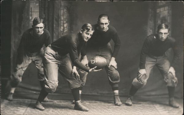 Four Football Players Crouching with Ball Studio Photo