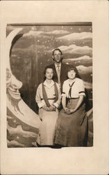 Man and Two Women on Paper Moon Postcard