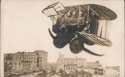 Three men posing in airplane flying above city skyline Studio Photo Postcard