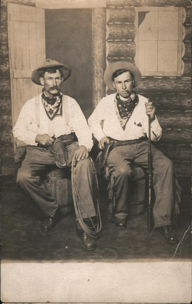 Two Men dressed as Cowboys sitting outside the Saloon