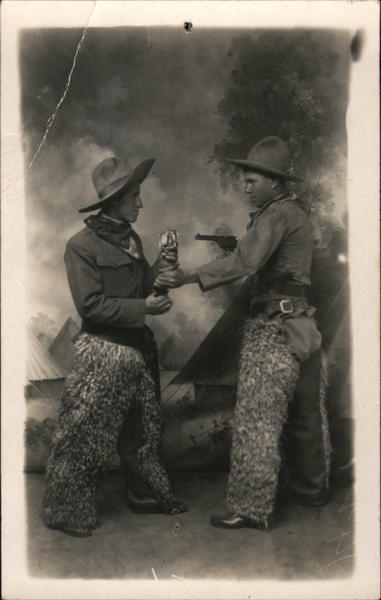 Two Men Dressed as Cowboys Wearing Wooly Chaps Hold-Up