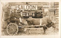 Family gets picture taken on a cart in front of Saloon Sign Postcard