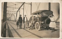 People standing by car on bridge Postcard