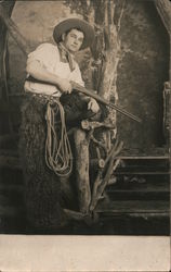 Man Dressed as Cowboy Wearing Wooly Chaps Holding Rifle Postcard