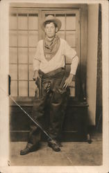 Man Dressed as a Cowboy Wearing Chaps and Holding a Pistol Postcard