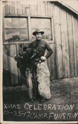 1917 Camp Funston Man Dressed as a Cowboy Wearing Wooly Chaps Holding Saddle Postcard