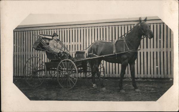 Vintage black-and-white photo of man driving horse-drawn buggy